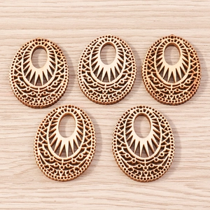 Macro detail of laser cut oval wood pendants with ethnic geometric hollow patterns