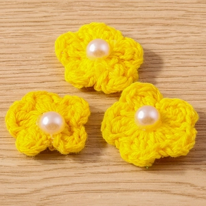 Vue détaillée de pendentifs fleurs jaunes tricotés main avec perle pour création de bijoux