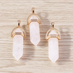 Macro detail of three rose quartz hexagonal bullet pendants with rose gold metal caps
