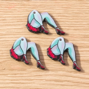 Detail of vintage mermaid skeleton leg pendants with red skirts for DIY jewelry making