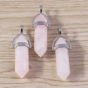 Detailed view of three rose quartz hexagonal prism bullet pendants with silver metal clasps