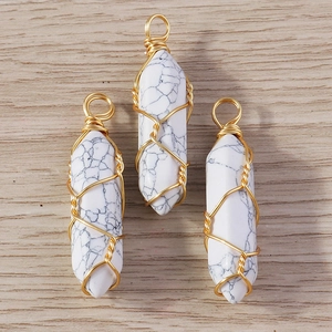 Macro detail of white howlite hexagonal stone pendants with gold wire wrapping