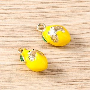 Detail view of 2 lemon charms with yellow enamel and green leaves for DIY jewelry making