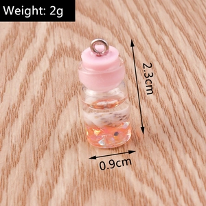 Detail of 2.3cm mini resin bottle pendant with pink cap and colorful glitter inside