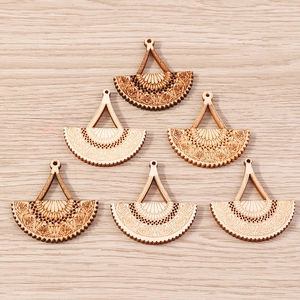 Detailed view of six semi-circular laser-cut wooden pendants with ethnic geometric patterns