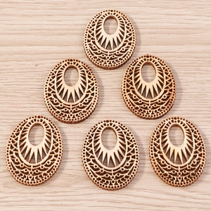 Detail of laser cut oval wood pendants with hollow geometric patterns for DIY jewelry