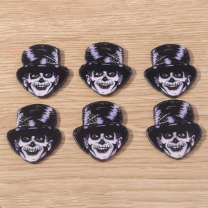 Macro detail of acrylic skeleton gentleman charms with purple hats for DIY jewelry