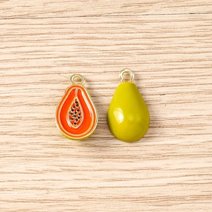 Detail showing enamel papaya fruit charm with orange pulp, black seeds and green peel