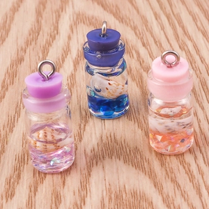 Detailed view of mini drift bottle pendants in purple, blue and pink with shell inserts