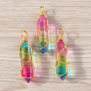 Set of crystal bullet pendants with wire wrapped golden wire on wood background