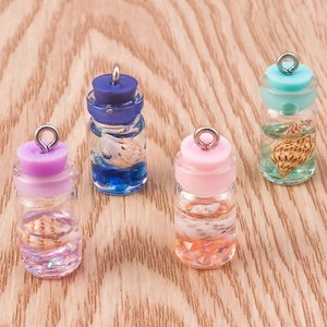 Detailed close-up of ocean-style mini glass bottles with shells and colorful sequins inside