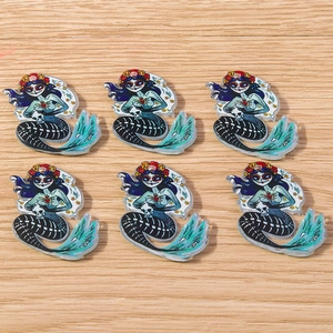 Detailed macro view of 6 skull mermaid pendants with Day of the Dead floral patterns