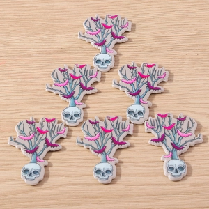 Macro view of six acrylic gothic skull pendants with dead tree branches and bats