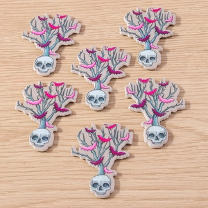 Detailed flat lay of Halloween skull and bat charms on a natural wood surface background