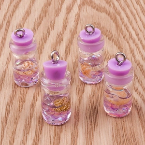 Detail view of mini shell wishing bottles with purple liquid and metallic loops