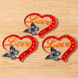 Detail of red heart acrylic charms with Love text and butterfly patterns for jewelry making
