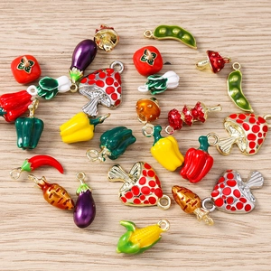 Detailed flat lay of colorful enamel vegetable charms on a natural light wood background