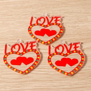 Detail of transparent acrylic heart charms with LOVE lettering and red hearts set of 3