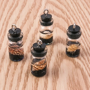 Macro shot of miniature ocean theme glass bottle pendants with shells and metal rings