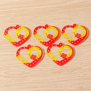 Detailed view of red and yellow acrylic heart pendants with LOVE cutout and rose motif