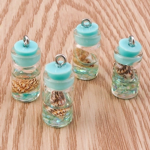 Macro shot of ocean style mini glass drift bottle pendants with tiny shells and glitter