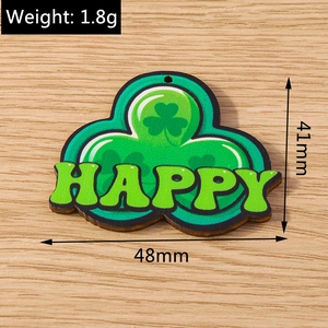 Macro detail of a 48mm green wooden clover pendant with Happy lettering for Saint Patrick's Day