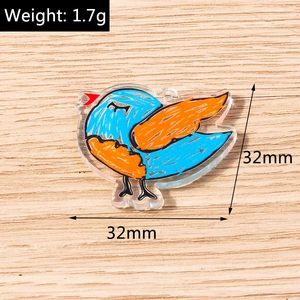 Detail view of a 32mm colorful bird acrylic pendant for bracelets on a wood background