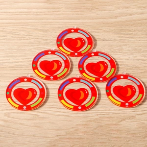 Macro view of six acrylic heart pendants with rainbow borders on a wooden surface