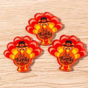Close-up of Thanksgiving turkey acrylic pendants with Give Thanks text and pumpkin charm