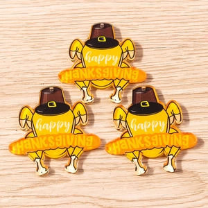 Three acrylic Thanksgiving turkey pendants with Happy Thanksgiving text on wood surface