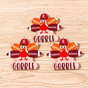 Close-up of Thanksgiving turkey acrylic pendants with football feathers and Gobble text
