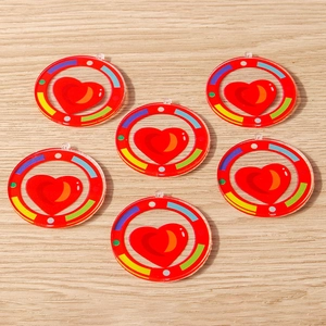 Set of six colorful heart acrylic pendants with rainbow ring borders on wooden background