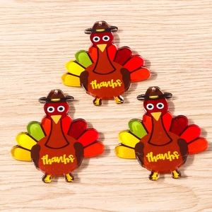 Macro shot of colorful acrylic turkey charms with thanks text on a wooden background