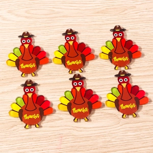 Detailed view of six acrylic Thanksgiving turkey pendants with thanks text on wood