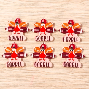 Detail of turkey pendants with football feathers and Gobble text on wood background