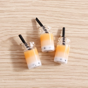 Detailed macro of 3D bubble tea resin charms with tiny black pearls and orange gradient