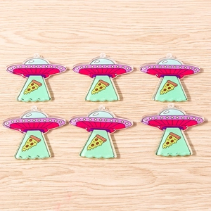 Detailed macro view of six UFO pizza acrylic pendants on light wood background