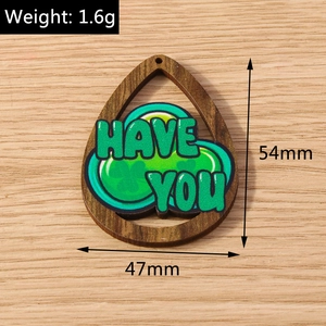 Teardrop wood charm detail with green clover and 'HAVE YOU' text, size 54mm x 47mm