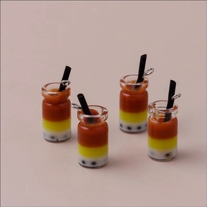 Macro view of four miniature layered bubble tea charms with silver hanging loops