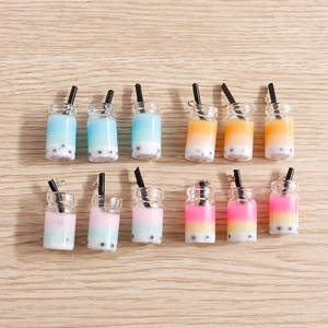 Macro view of assorted resin boba tea pendants with colorful gradient and straw details