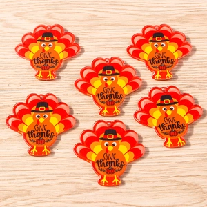 Flat lay of turkey shaped Give Thanks pendants for Thanksgiving jewelry making