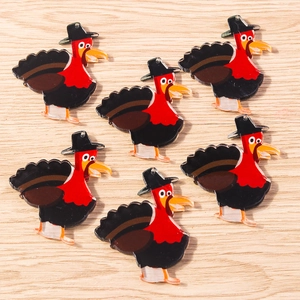 Close-up of turkey acrylic charms with pilgrim hats on wooden background for DIY crafts