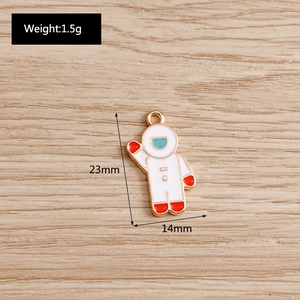 Macro shot of 23mm astronaut pendant with dimensions shown on wooden background