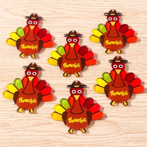 Detail view of acrylic Thanksgiving turkey pendants with thanks text on wooden background