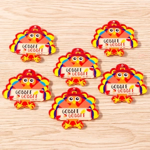 Macro shot of colorful acrylic Thanksgiving turkey pendants with Gobble Gobble text