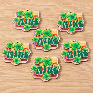 Macro detail of laser-cut wooden St. Patrick's Day shamrock charms with MINE text