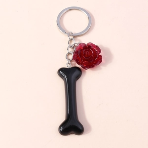 Detail of red resin rose and glossy black bone charm on silver metal keychain
