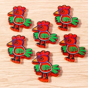 Detailed close-up of orange acrylic turkey charms with hanging holes for DIY jewelry