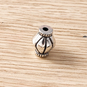 Macro shot of vintage style rhicombus metal spacer bead with engraved vertical lines