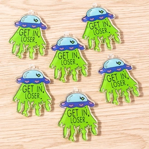 Macro detail of acrylic UFO DIY charms with green beam and Get In Loser slogan